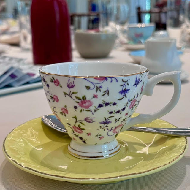 White teacup with pink and cornflower blue flowers at the NYBG Wonderland afternoon tea.