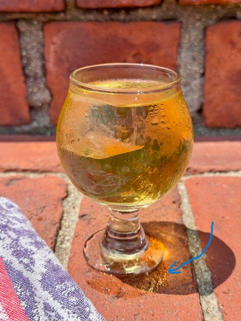 Iced tea in a glass with condensation on the glass and a condensation ring beneath it.