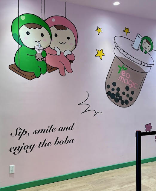 Wall mural at Tea Magic in Williston Park featuring cartoon "tea fairies," a boba tea, and the words "Sip, smile and enjoy the boba."
