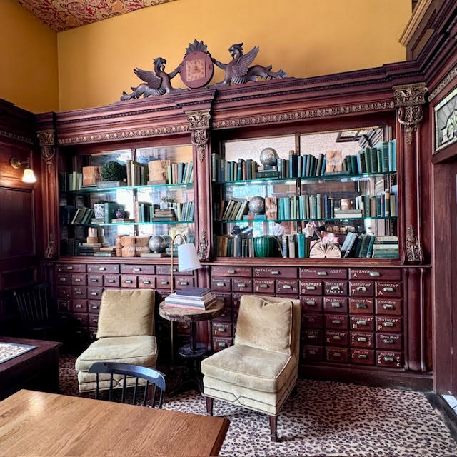 Apothecary drawers and antique clock with griffins at Gryphon.