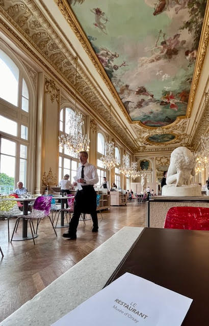 View of the  Restaurant Musée D'Orsay showing beautiful ceiling fresco, gilded molding, statue, and chandeliers.