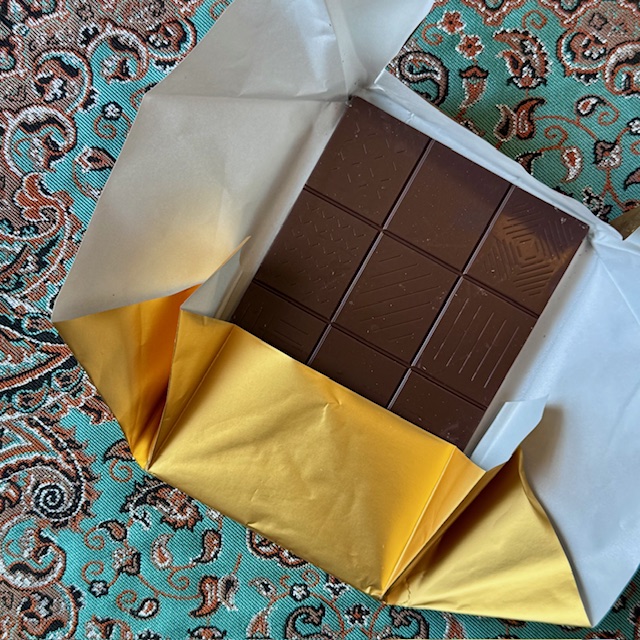 dark brown tea-infused chocolate bar in a half-open gold foil wrapper